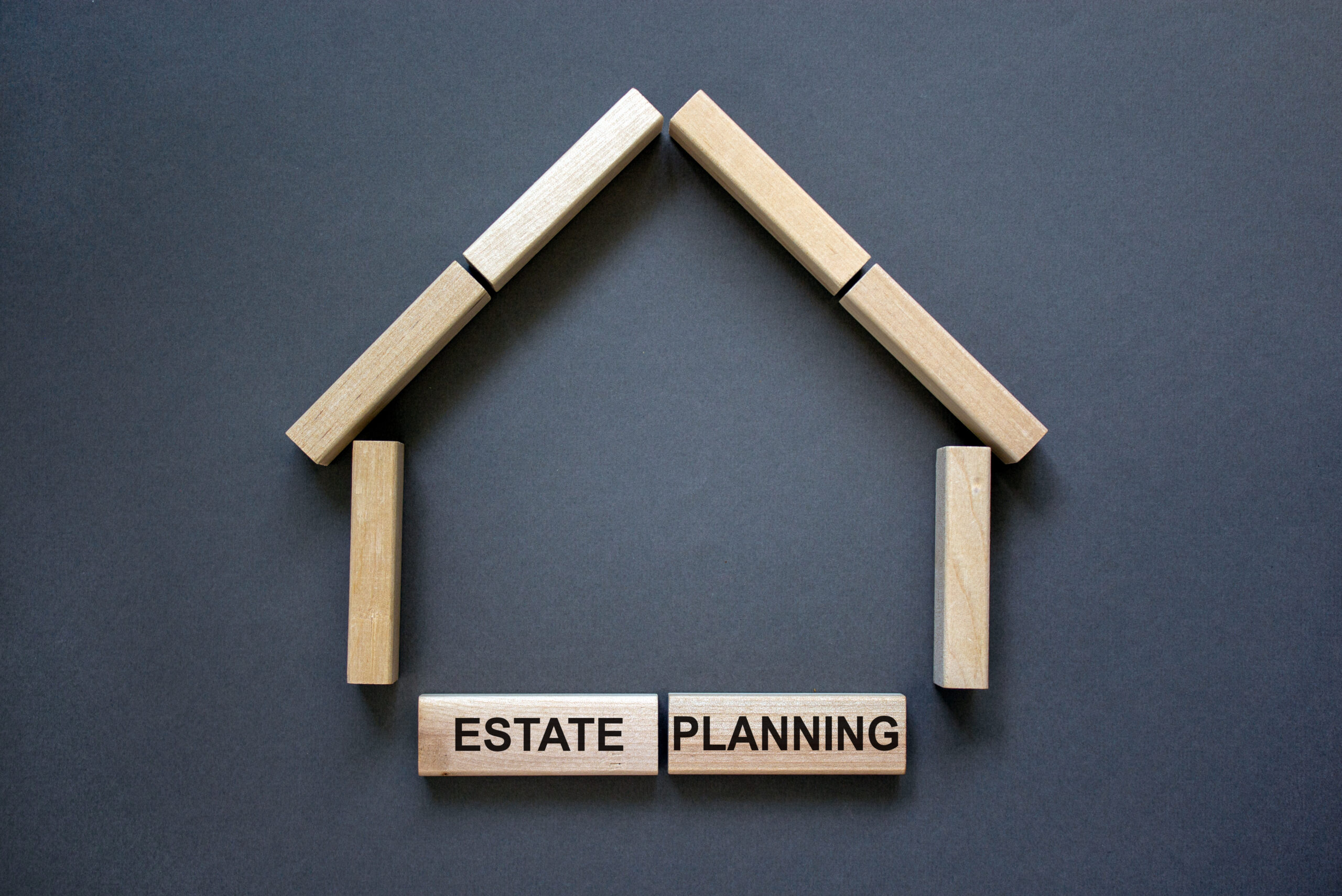 Wooden blocks in the outline of a house with "Estate Planning" written on the foundation blocks