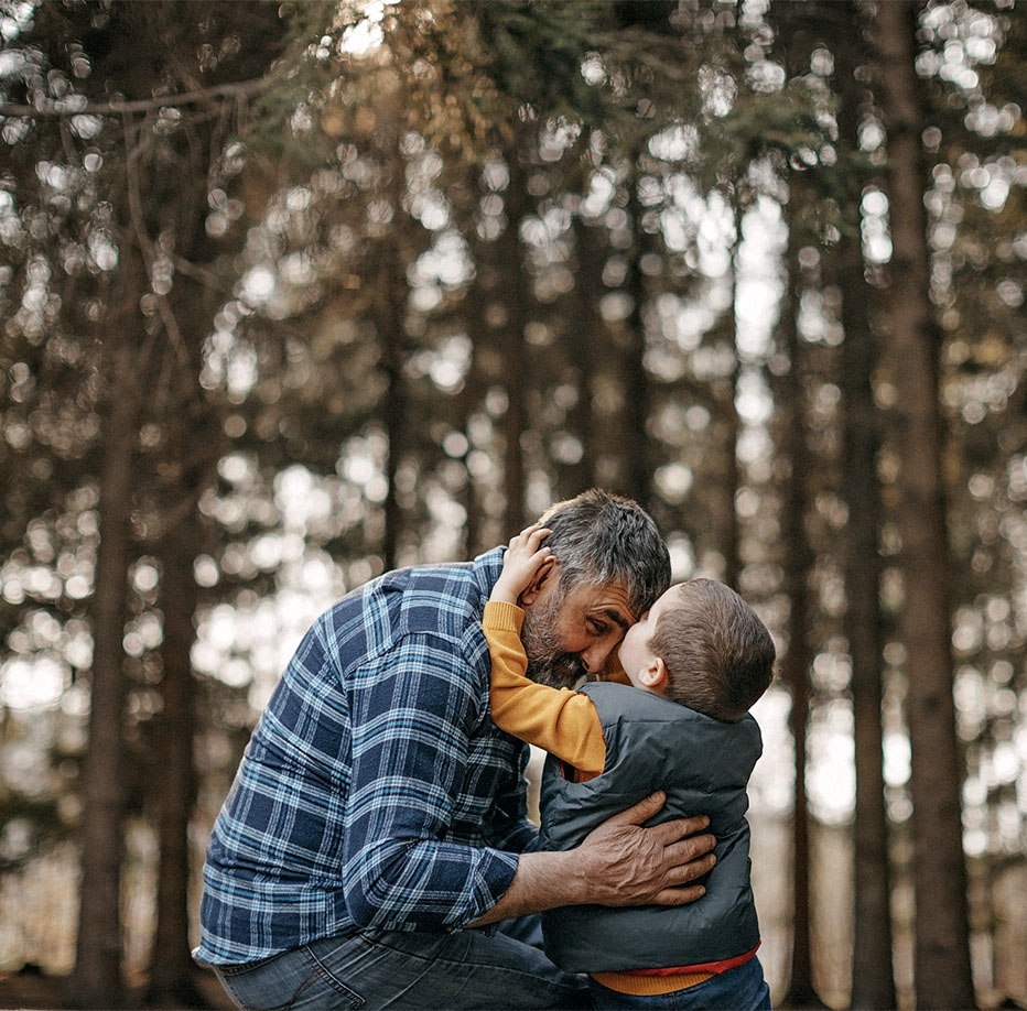 Little boy gives man a kiss on the forehead