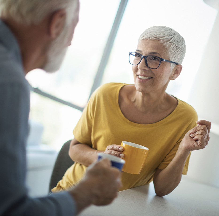 Woman holding a coffee mug looking at her husband