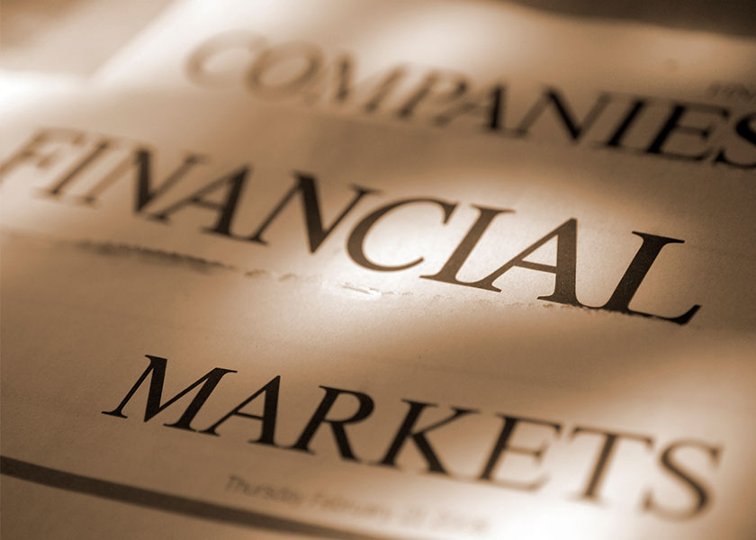 A close-up of sepia-toned financial newspapers, prominently displaying the words companies, financial, and markets.