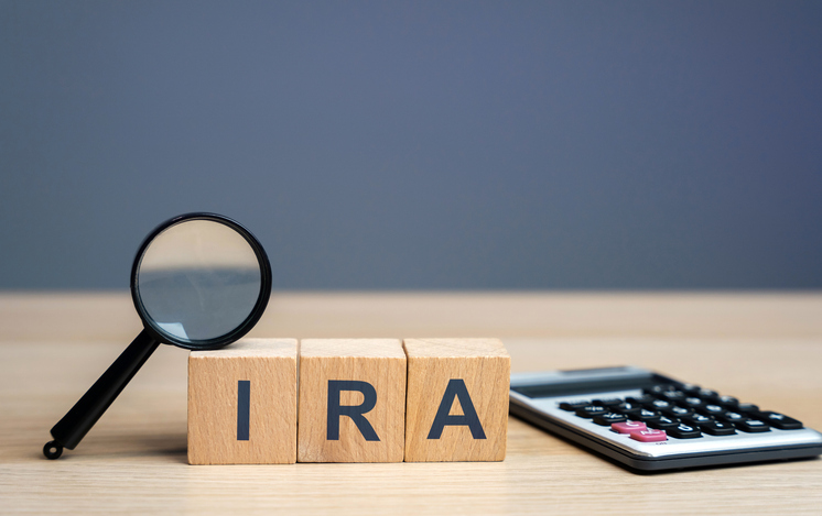 Wooden blocks with the word IRA - individual retirement account. Tax-advantaged account that individuals use to save and invest for retirement.